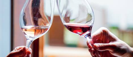 Two hands holding wine glasses with a blurred background.