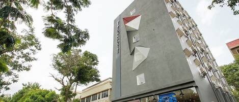 Un edificio moderno con una puerta roja y una escalera que lleva a la entrada.