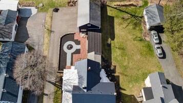 An aerial view of a residential area with houses, a driveway, and a swimming pool.