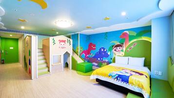 A children's room with a bed, green walls, a play area, and a mural.