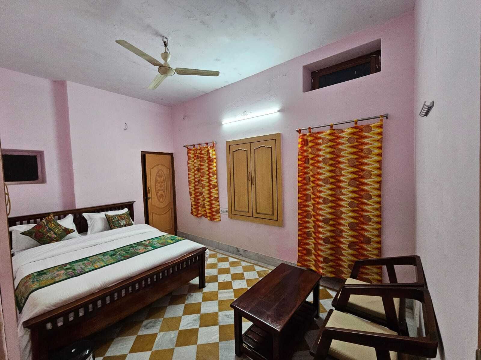 A bedroom with a bed, a desk, and a chair.