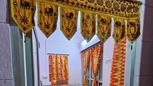 A narrow hallway with a reception area, patterned curtains, and a bench. - Hotel Blue Diamond Jaisalmer (Jaisalmer)