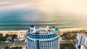 Un hôtel de grande hauteur doté d’une piscine sur le toit et offrant une vue sur la plage.