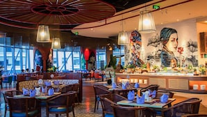 Un restaurant au décor moderne, agrémenté d’une fresque murale, d’un espace buffet et d’un plafond au design rouge original.