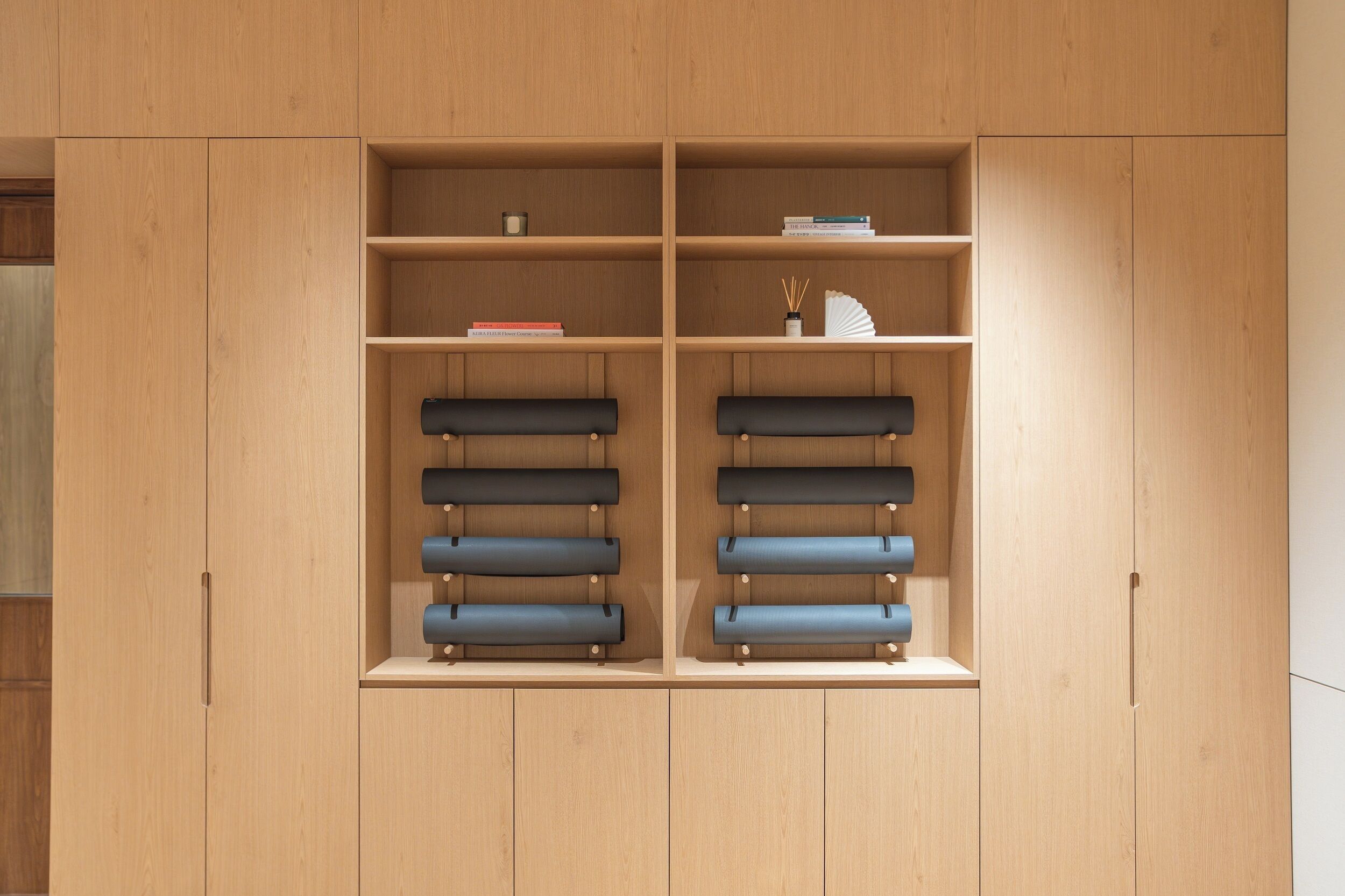 A wooden wardrobe with multiple shelves and drawers, some containing books and decorative items.