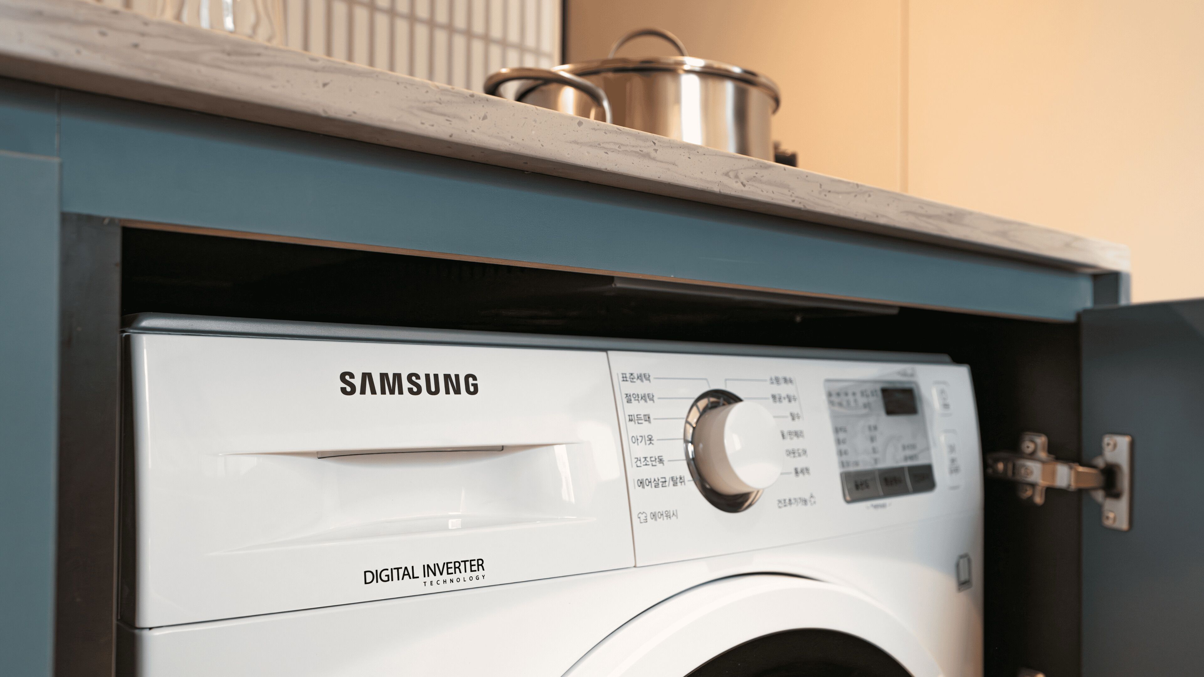 Una lavadora Samsung con tecnología digital inverter, un panel de control y una tina de acero inoxidable en la parte superior.
