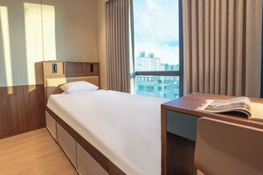 A hotel room with a bed, a desk, and a view of the cityscape. - Weave Suites - Sunyu Parkside (Seoul)