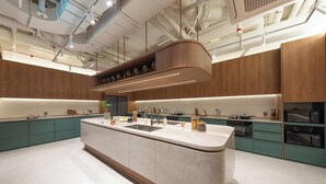 A modern kitchen with a central island, built-in appliances, and a sleek design. - Weave Suites - Sunyu Parkside (Seoul)