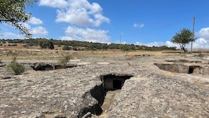 Un sitio arqueológico con antiguas estructuras de piedra y senderos.