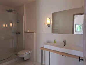 A modern bathroom with a glass-enclosed shower, a white toilet, and a vanity with a mirror and a sink. - Logis Hotel Le Clos Des Sullys (Montclus)