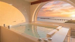 A spa area with a large bathtub and a view of the sunset over the ocean. - Samcheok Peacehousing Spa Pet Pension (Samcheok)