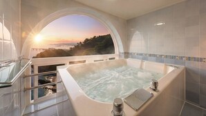 A bathroom with a large bathtub, a view of the sunset, and a glass railing overlooking a body of water. - Samcheok Peacehousing Spa Pet Pension (Samcheok)