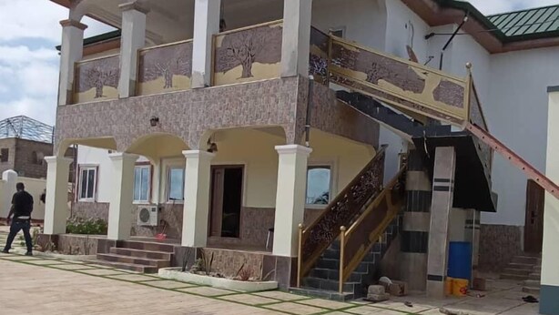 Un edificio de dos pisos con un balcón y una escalera que conduce al piso superior.