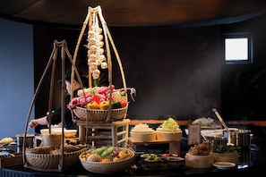 A buffet setup with various food items and a person serving. - Signature by M Village Lê Thánh Tôn, a brand of Modern Village Lifestyle (Ho Chi Minh City)