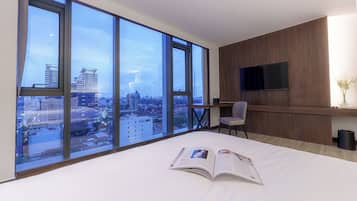 Habitación Deluxe, vista a la ciudad | Sala de estar | Televisión