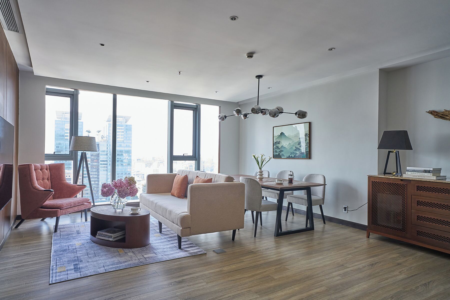 A modern living room with a sofa, armchairs, a coffee table, and a dining area.