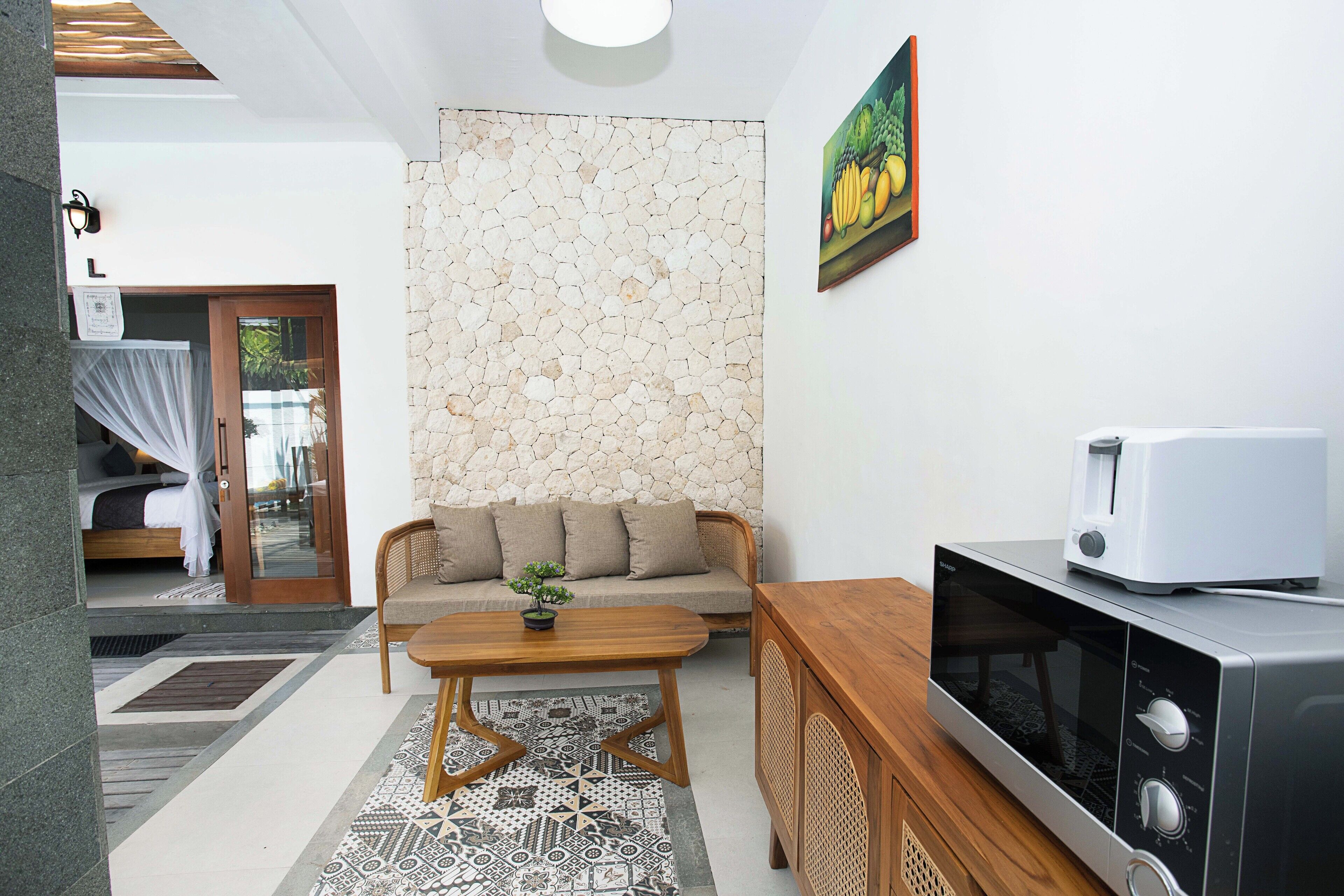 Un espacio habitable compacto con kitchenette, un sofá, una mesa de centro y un comedor.