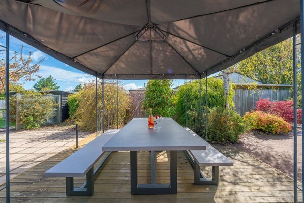 Enjoy a romantic meal for two on this patio, surrounded by lush greenery and a serene atmosphere.