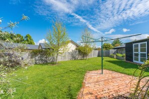 Enjoy a serene outdoor space with a well-maintained lawn and patio area surrounded by a fence.