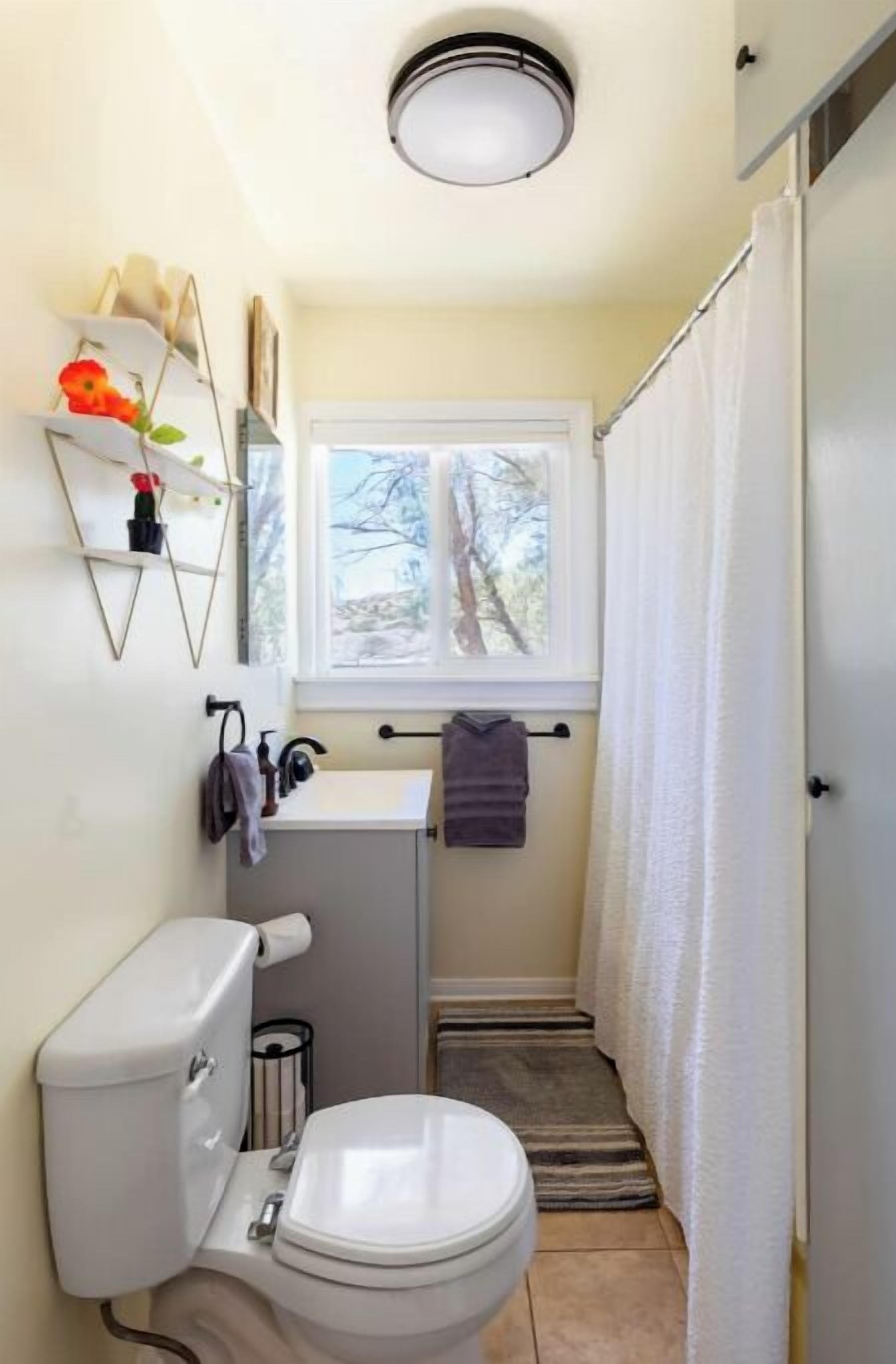 A compact bathroom with a toilet, sink, and window.