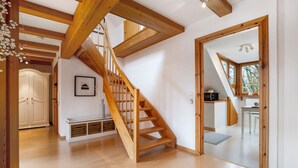 A spacious room with a wooden staircase, a white wardrobe, and a framed picture on the wall. - Apartment 'Hannover Südstadt-Perle' with Private Garden and Wi-Fi (Hannover)