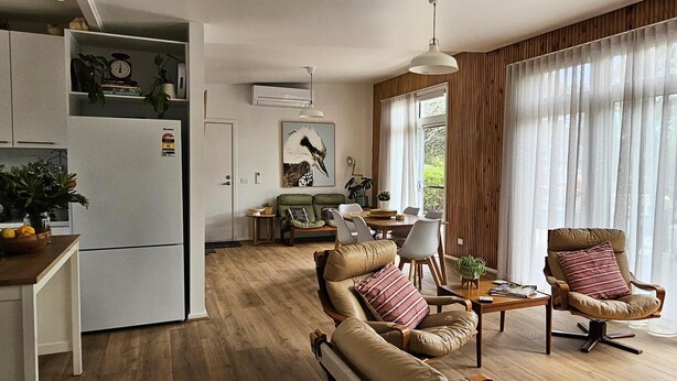 Un salon moderne avec un canapé, des fauteuils et un coin repas.