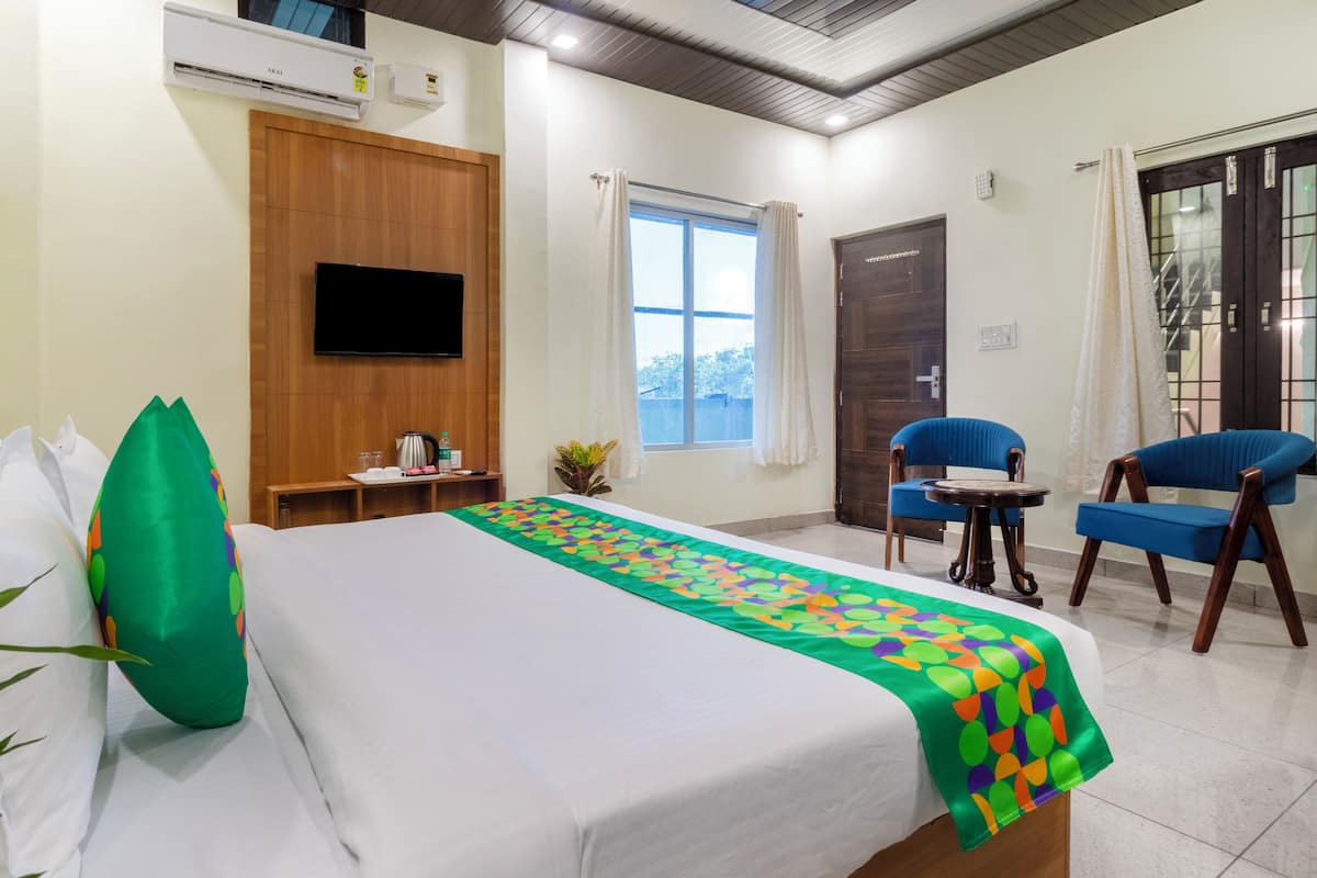 Una habitación de hotel con cama, televisión, escritorio, silla y ventana.