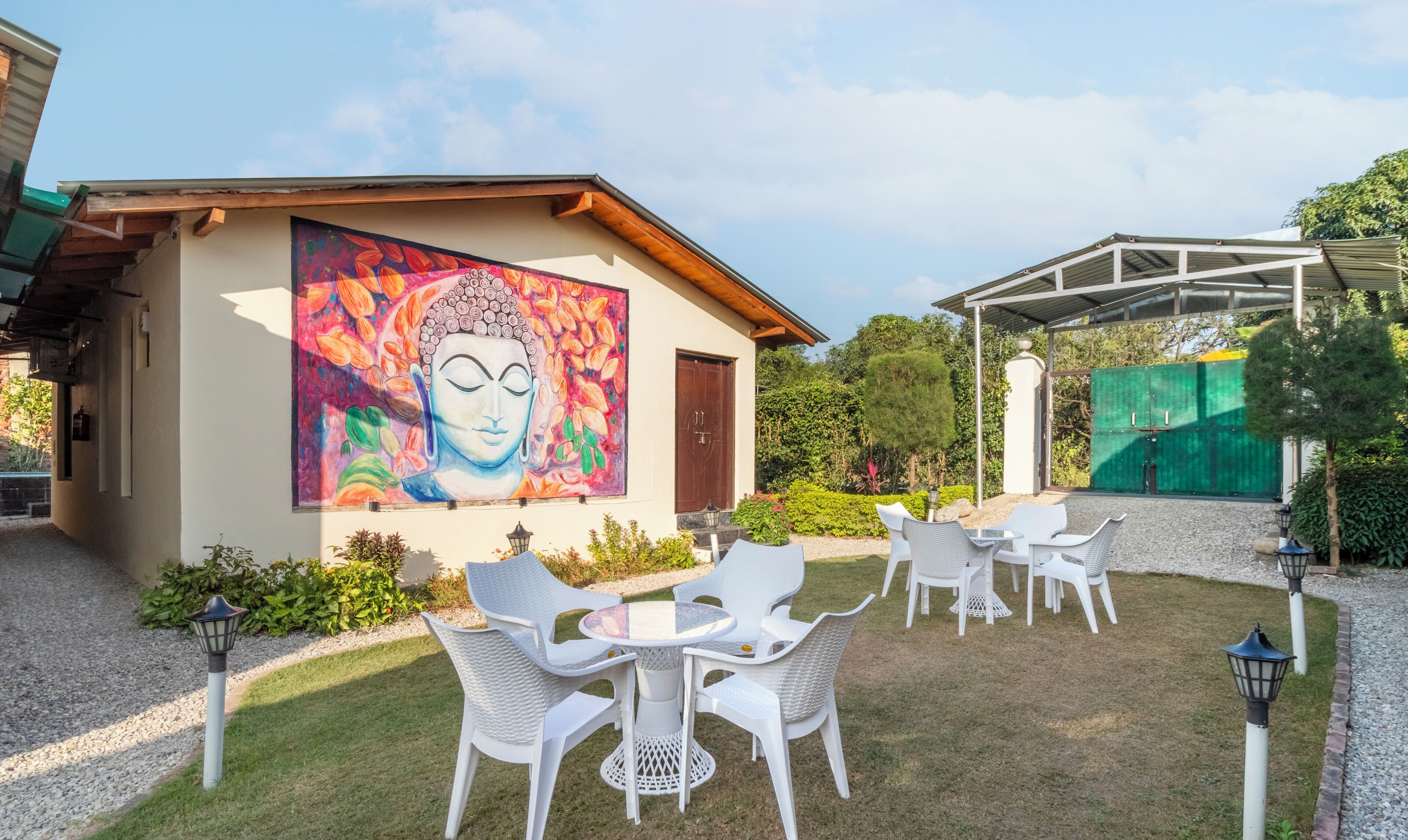 Un bâtiment orné d’une fresque représentant un Bouddha, doté d’une terrasse et d’un espace abrité.