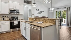 A modern kitchen with white cabinetry, stainless steel appliances, a granite countertop, and pendant lighting. - Waterfront 3BR Home | Private Boat Ramp & Firepit | 2 Small Dogs Welcome (Middleburg)