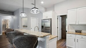 A modern kitchen with white cabinets, a stainless steel refrigerator, and a granite countertop. - Waterfront 3BR Home | Private Boat Ramp & Firepit | 2 Small Dogs Welcome (Middleburg)