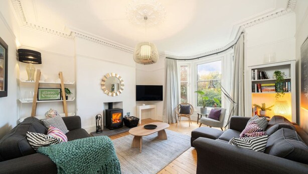 A modern living room with two sofas, a coffee table, a fireplace, a television, and a bookshelf. - Sunnybrae House Seaside Family-friendly Getaway in Stonehaven With Hot Tub (Stonehaven)