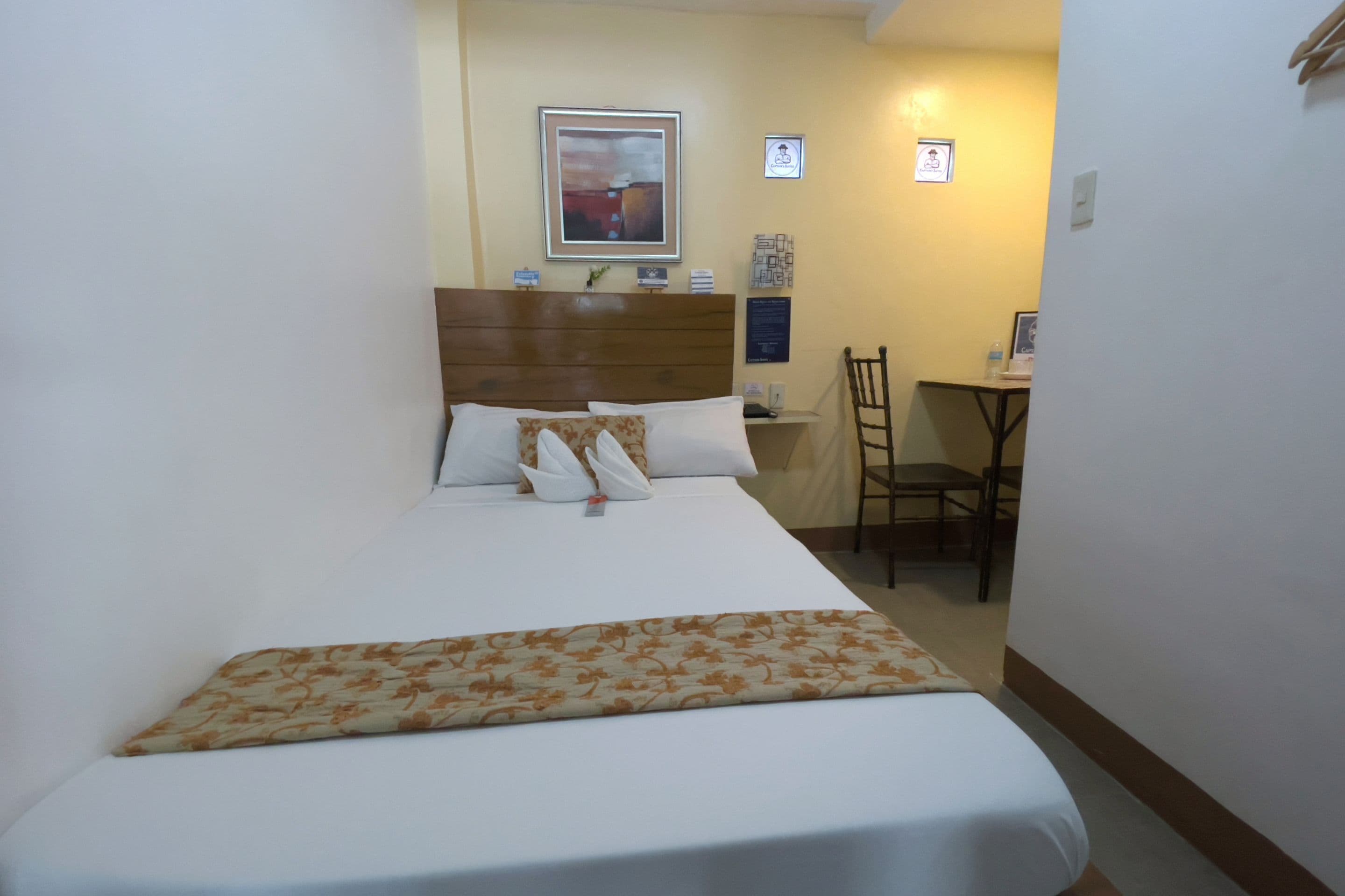 Una habitación de hotel con cama, escritorio y silla.