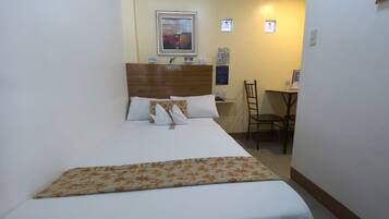 Una habitación de hotel con cama, escritorio y silla.