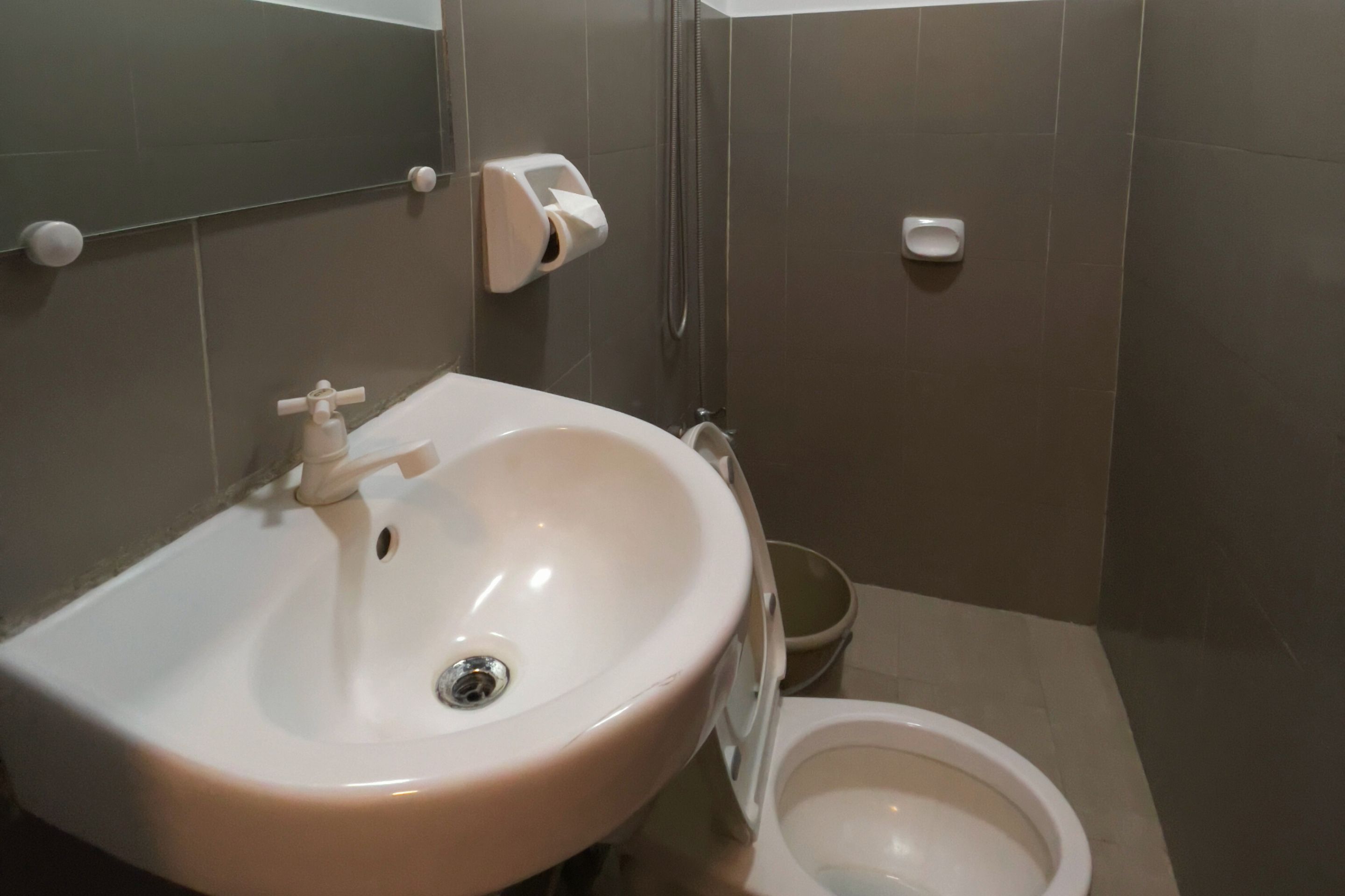 Un baño con lavamanos, inodoro y secador de manos.