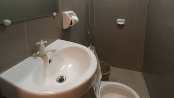 Un baño con lavamanos, inodoro y secador de manos.