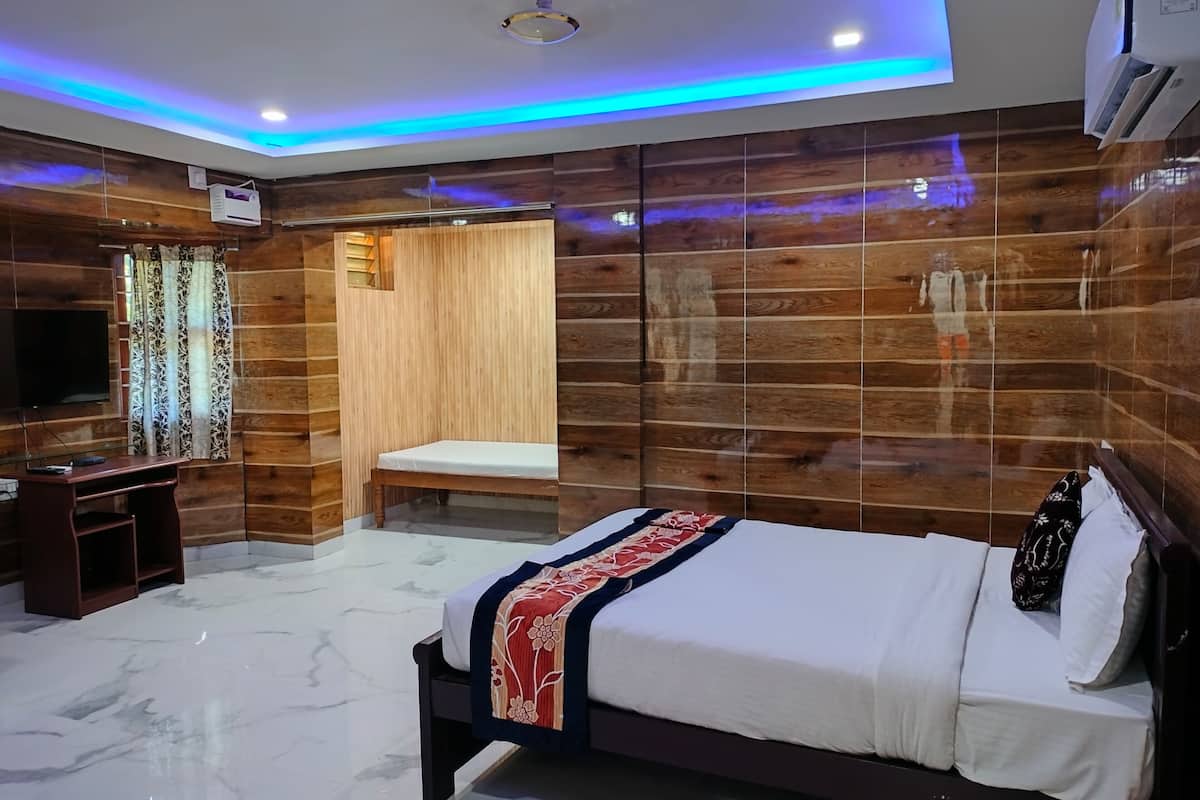 Un dormitorio moderno con cama, escritorio y televisor.