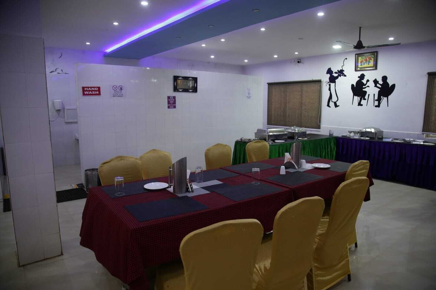 Una sala de conferencias con una larga mesa, sillas amarillas y una pantalla de televisión.
