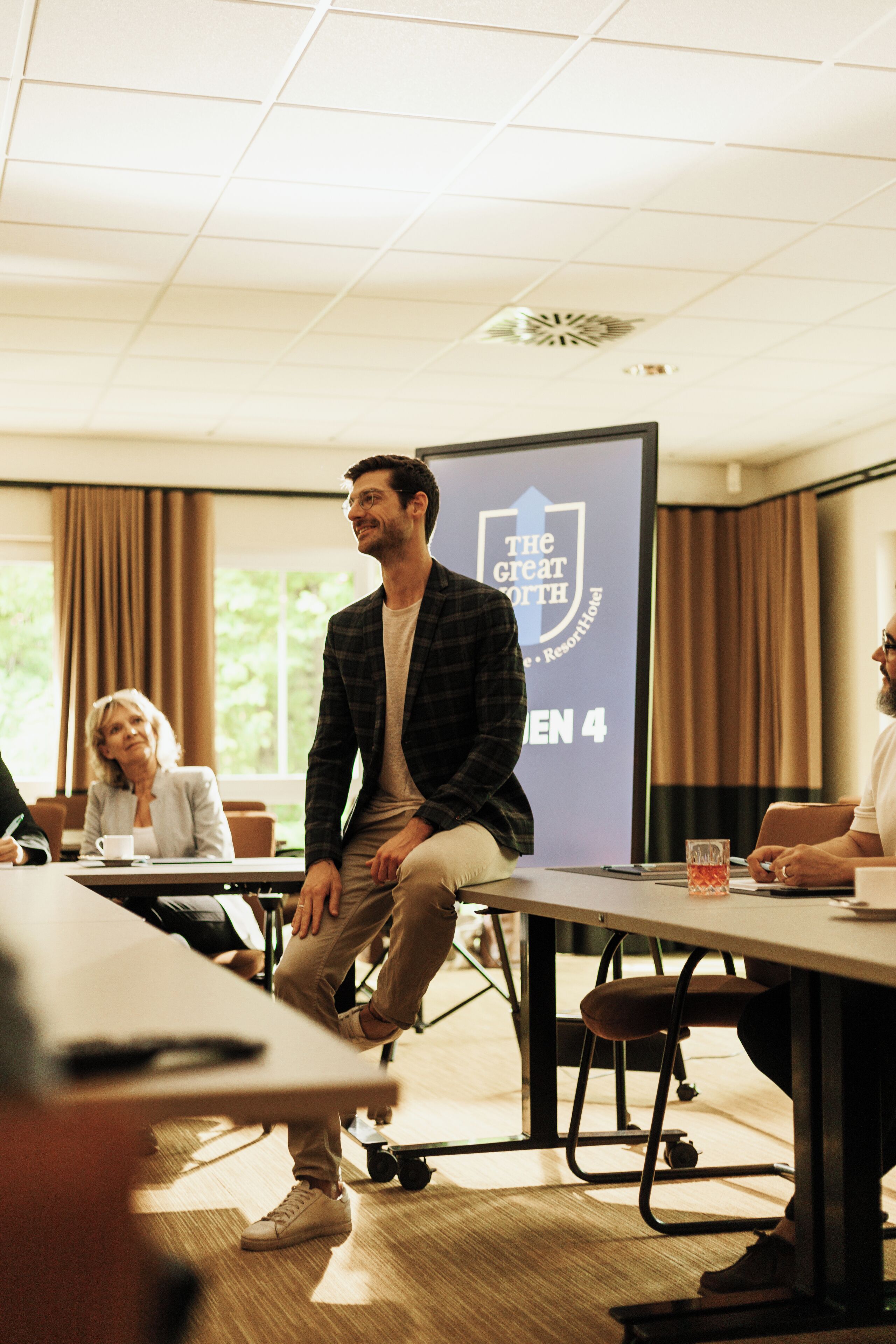 Ett konferensrum med en presentationsskärm som visar logotypen för "The Great North" och texten "GEN 4".