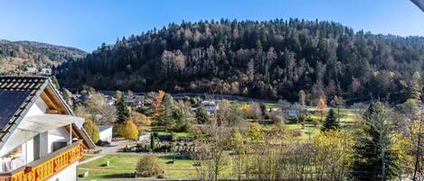 Blick auf ein Dorf mit einem markanten Gebäude, das einen Balkon und ein Schild besitzt.