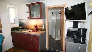 A compact kitchen with a microwave, a coffee maker, and a built-in oven. - Appartement Nr 5 mit Gemeinschaftsterrasse, Garten und WLAN (Todtmoos)