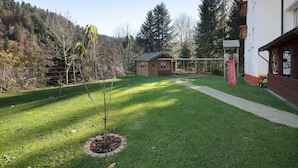 A residential area with a house, a swing set, and a fenced yard. - Appartement Nr 5 mit Gemeinschaftsterrasse, Garten und WLAN (Todtmoos)