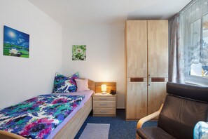 A bedroom with a bed, a nightstand, a wardrobe, and a window with curtains. - Apartment 'Appartement Nr 5' with Shared Terrace, Shared Garden and Wi-Fi (Todtmoos)