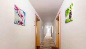 A hallway with wooden flooring, white walls, and two doors with red trim. - Apartment 'Appartement Nr 3' with Shared Terrace, Garden, and Wi-Fi (Todtmoos)
