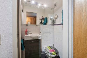 Une salle de bain équipée d’un lavabo, d’un miroir, d’un porte-serviettes et de toilettes.