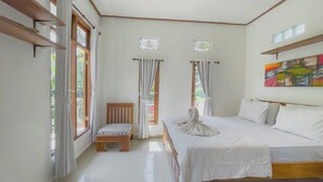 A bedroom with a bed, a chair, and two windows with curtains. - Surya Ubud View and Suites by EPS (Tegallalang)