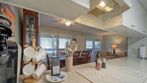 Una cocina con una isla grande, cafetera y un comedor con mesa y sillas.