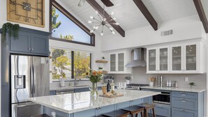A modern kitchen with a large island, stainless steel appliances, and a farmhouse ceiling. - Paso Vista Bella by AvantStay | Luxe Group Escape w/ Wine Country Views (Paso Robles)