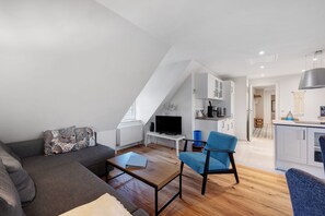 A modern living room with a sofa, a coffee table, and a TV.