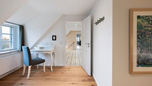A room with a desk, chair, window, and a painting on the wall. - Apartment 'Louisenkate' with Private Terrace, Private Garden and Wi-Fi (Pellworm)