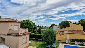 A residential area with houses, a swimming pool, and a clear sky.